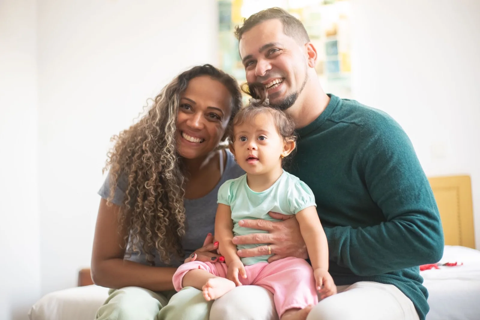 Smiling parents holding their young child at home